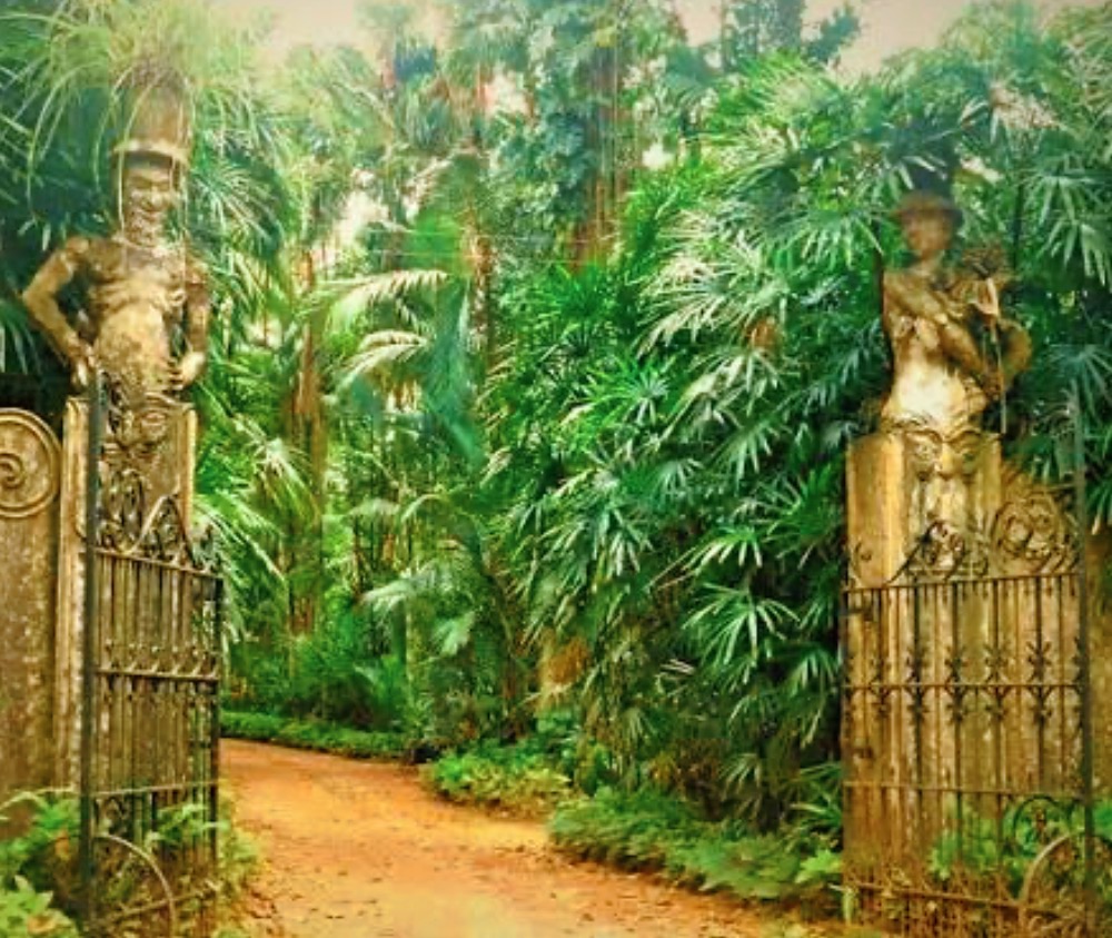Ornate old gates opening onto a lush tropical garden path