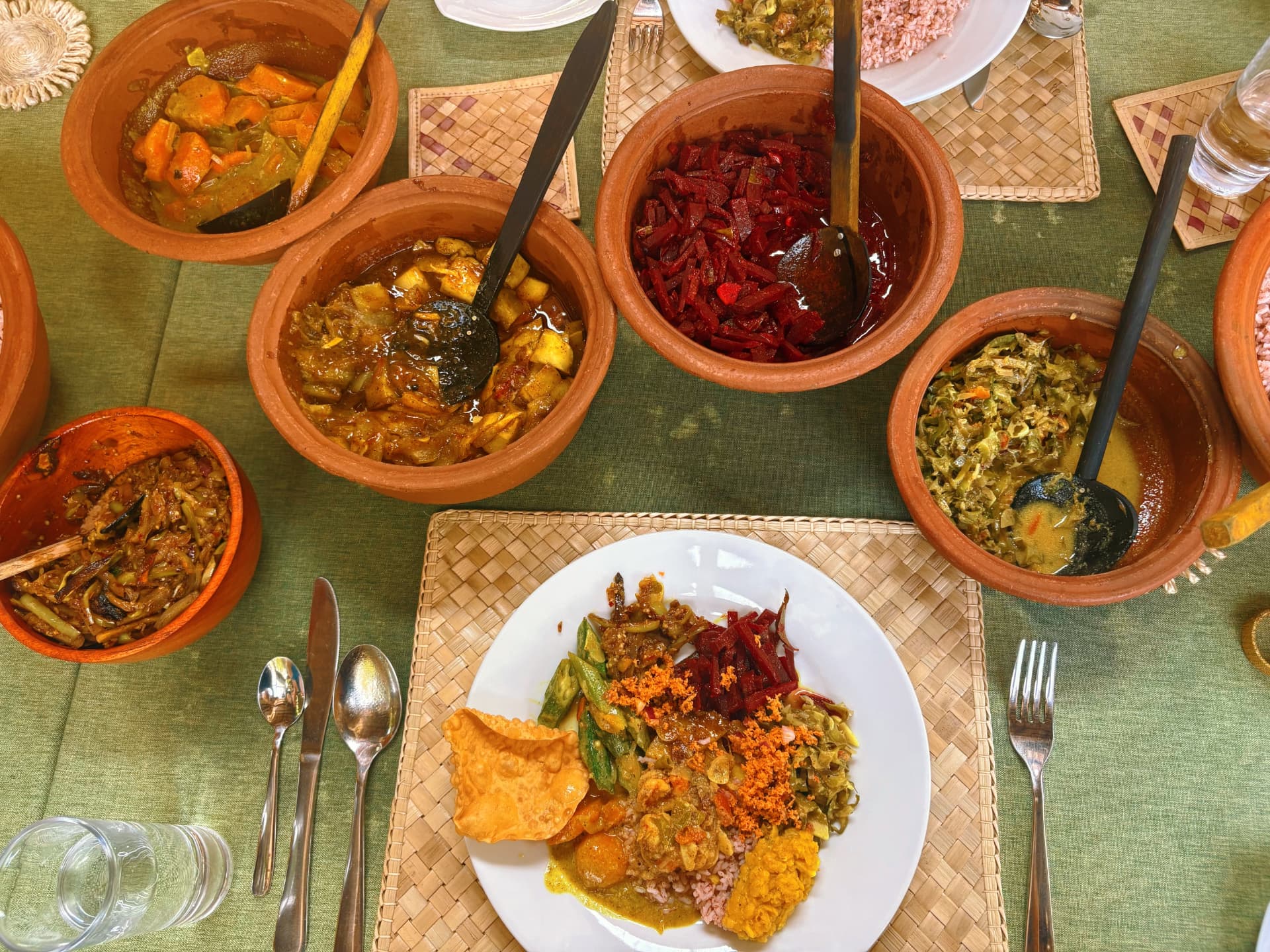 Colourful Sri Lankan curry spread served in clay bowls with rice and sambol